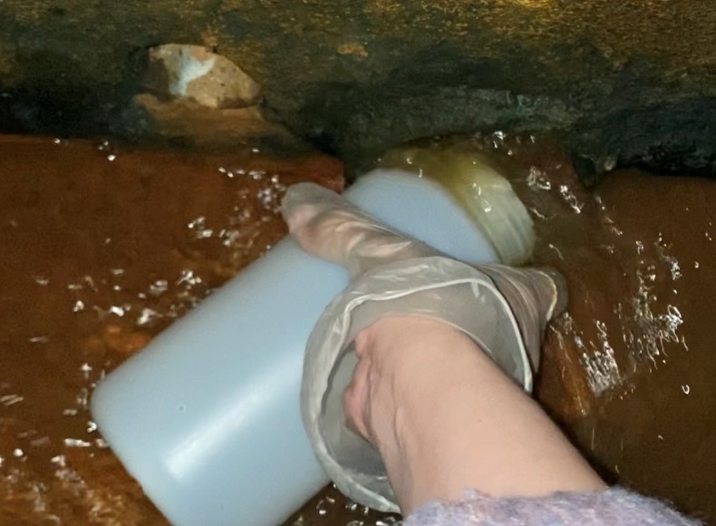 稽查人員於水溝旁隱密的孔洞中發現有大量電鍍廢水排出
