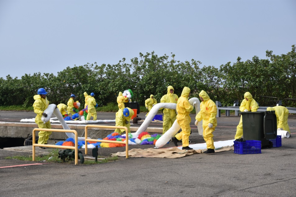 應變人員鋪設片狀吸油棉及澎澎來清除岸際油污